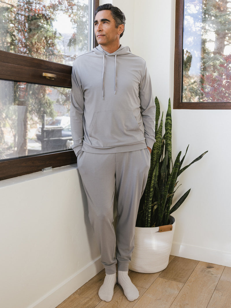 Stone Bamboo Hoodie and Jogger set worn by man standing in front of a window.