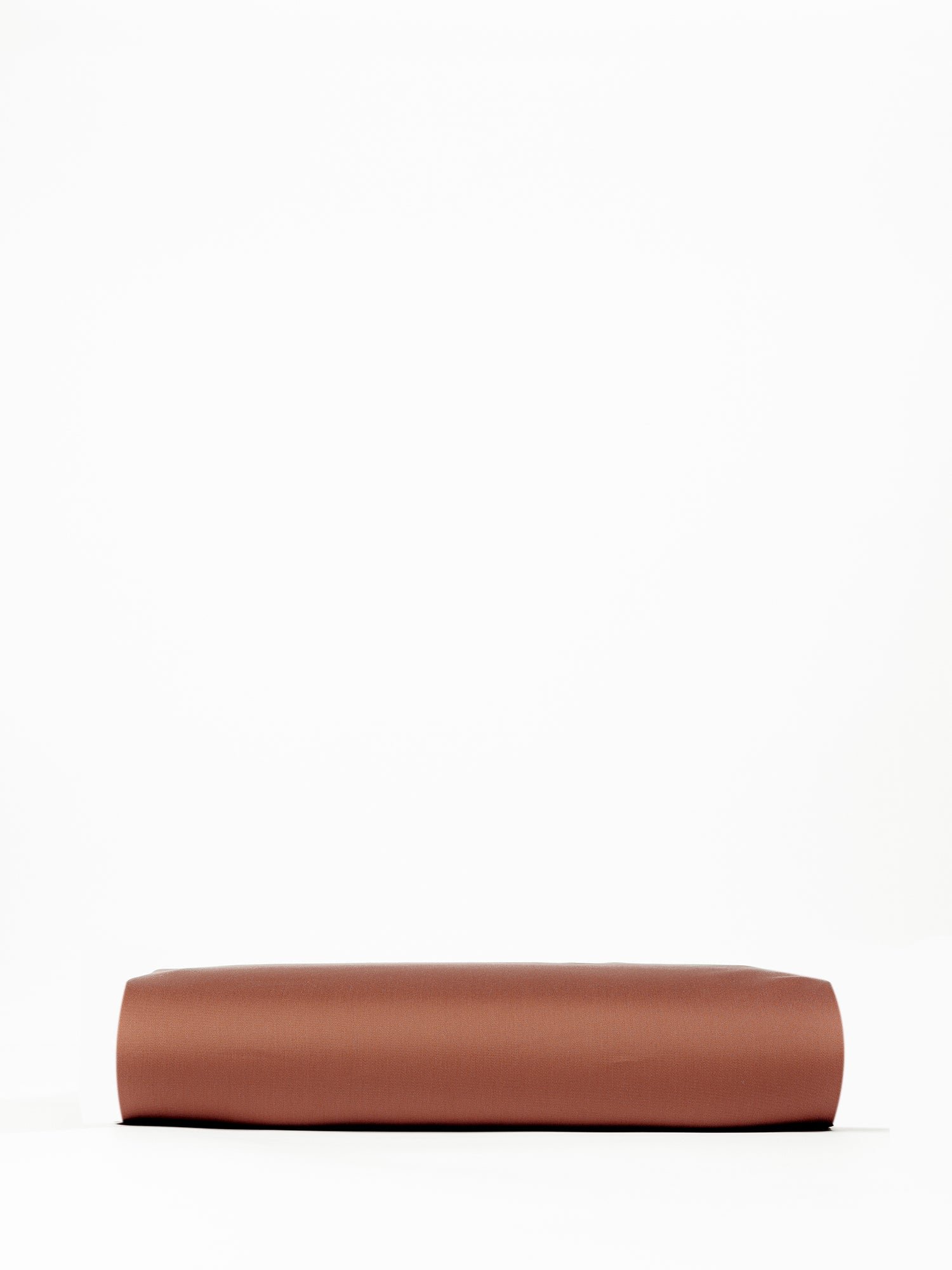 A neatly folded Bamboo Fitted Sheet from Cozy Earth, displayed against a plain white background. The sheet appears to be smooth and rectangular, resting flat with clean, defined edges. |Color:Terra