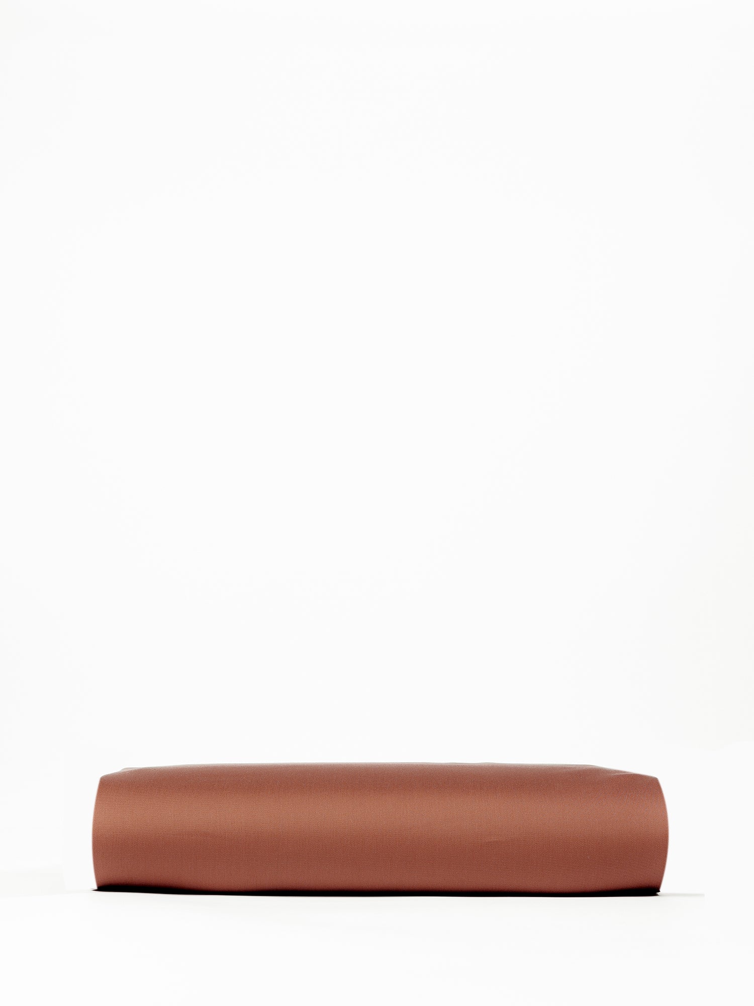 A neatly folded Bamboo Fitted Sheet from Cozy Earth, displayed against a plain white background. The sheet appears to be smooth and rectangular, resting flat with clean, defined edges. |Color:Terra