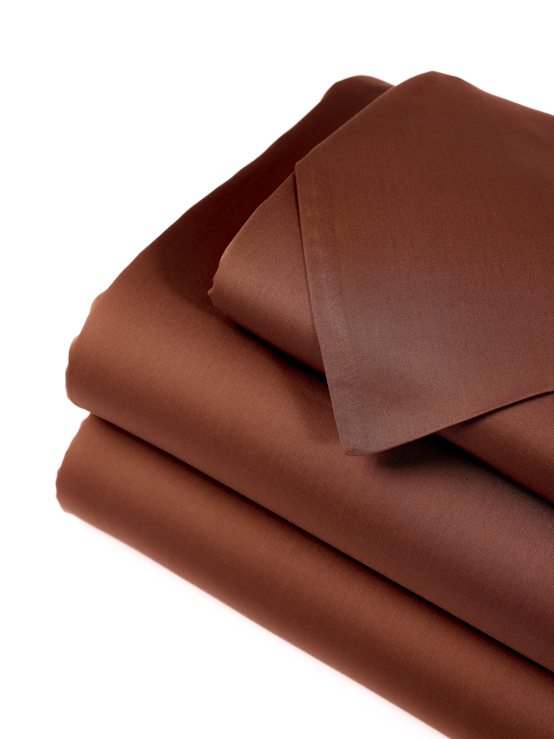 A neatly folded stack of Cozy Earth's Bamboo Sheet Set - Wholesale, in a rich dark brown color, including a pillowcase, displayed against a white background. The fabric appears smooth and soft, indicating its high-quality material. 