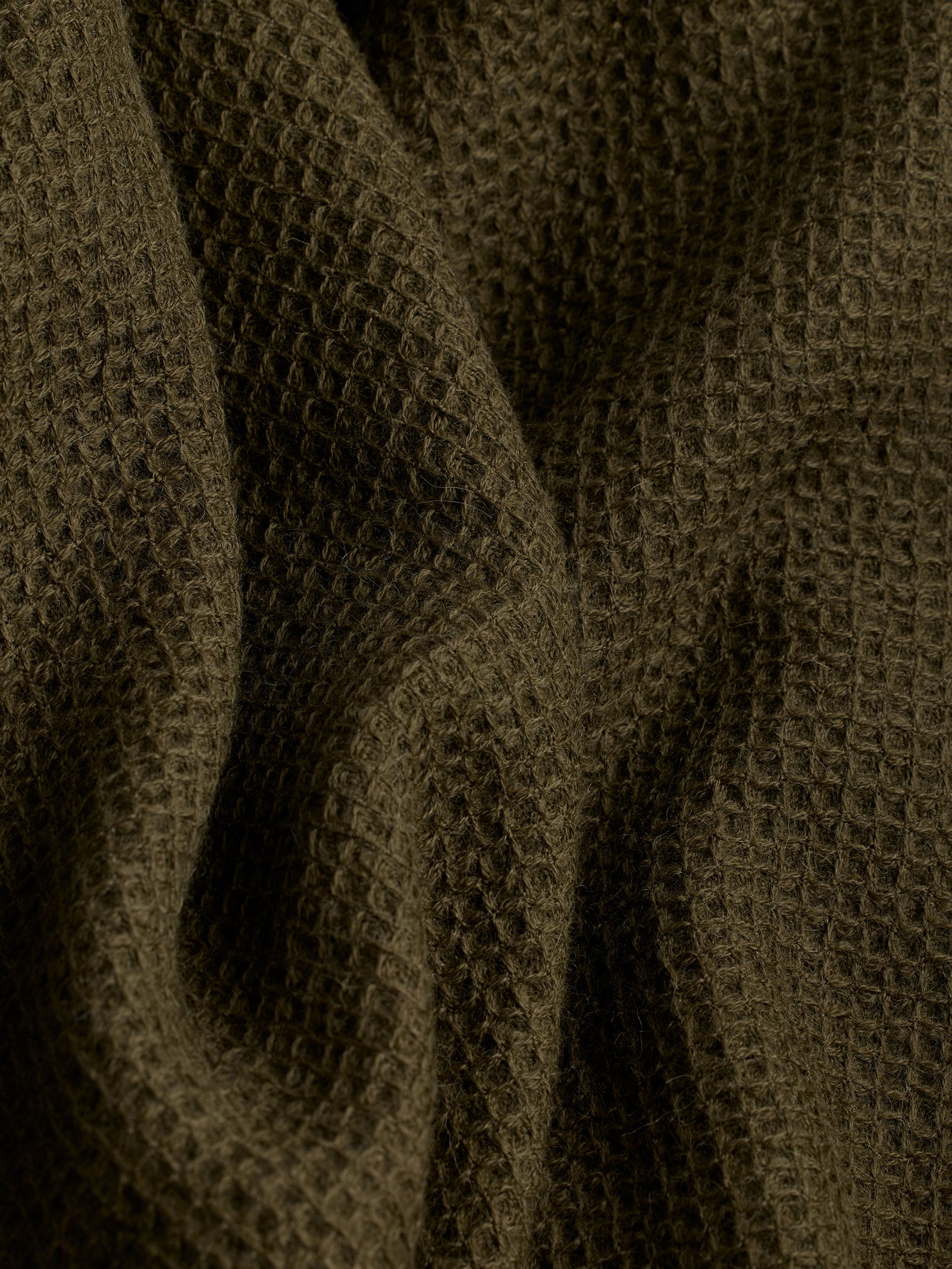 Close up of utility green alpaca throw 