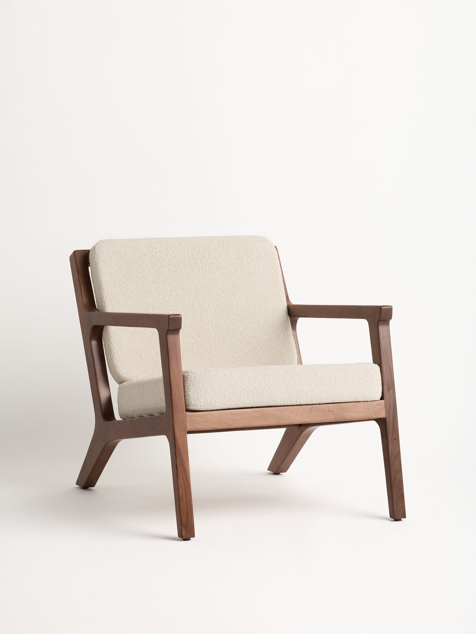 The Coronado Lounge Chair from Cozy Earth showcases a minimalist design with its light beige cushioned seat and backrest, set against a plain white background. 