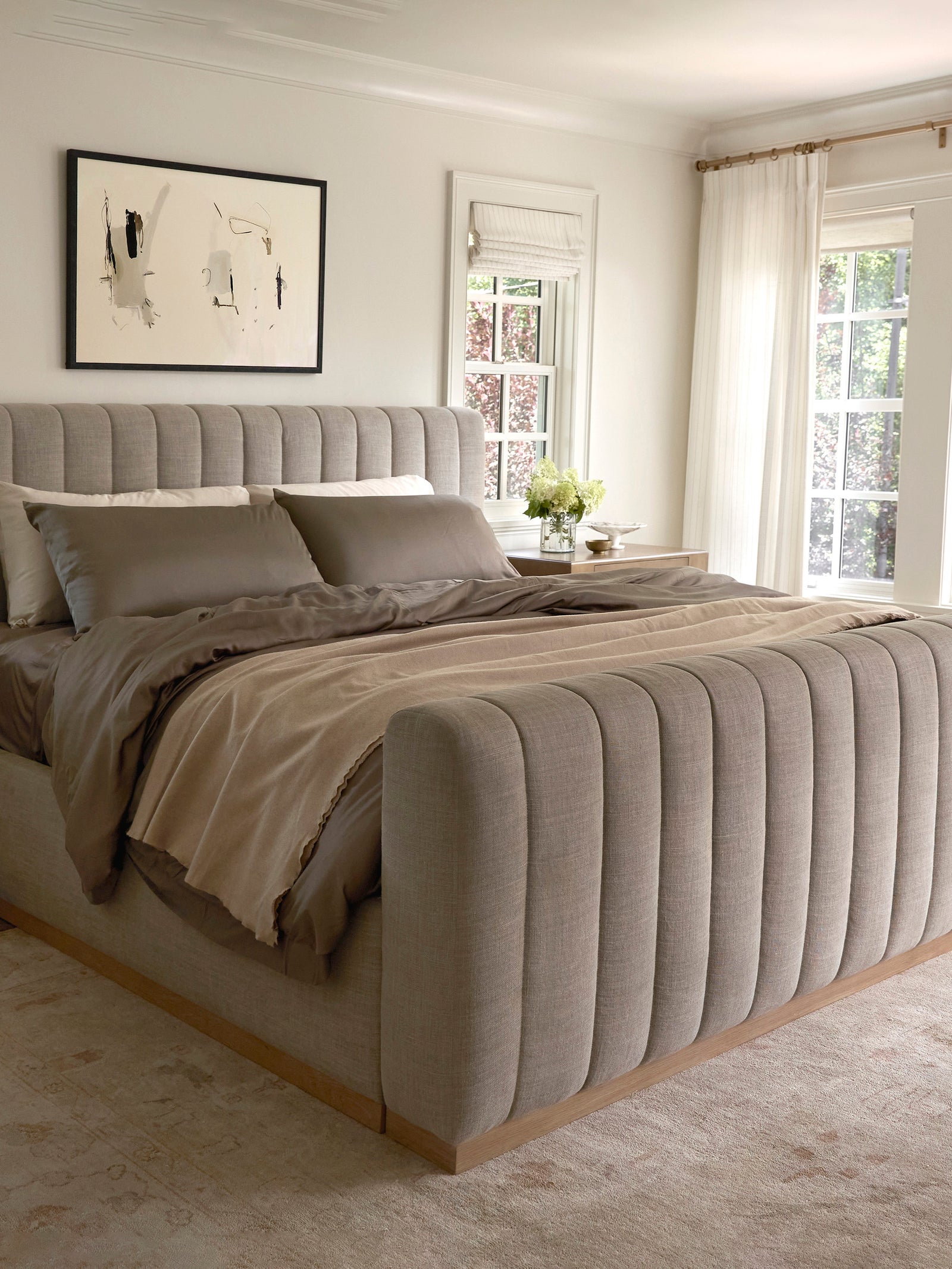 Bedroom with large bed with walnut bedding and a throw blanket standard/king/body