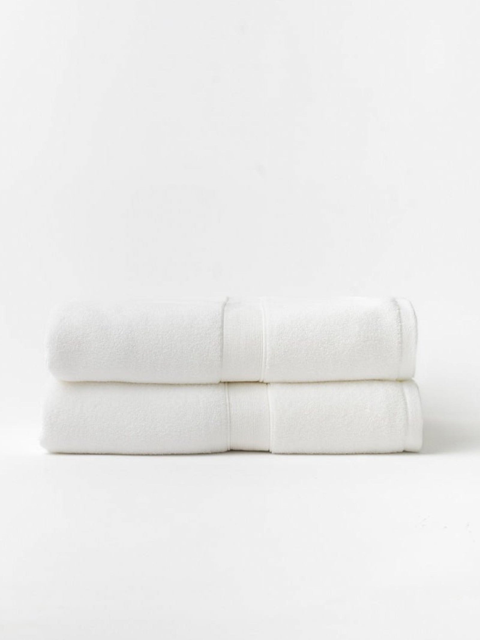 Two luxe bath sheets folded with white background 