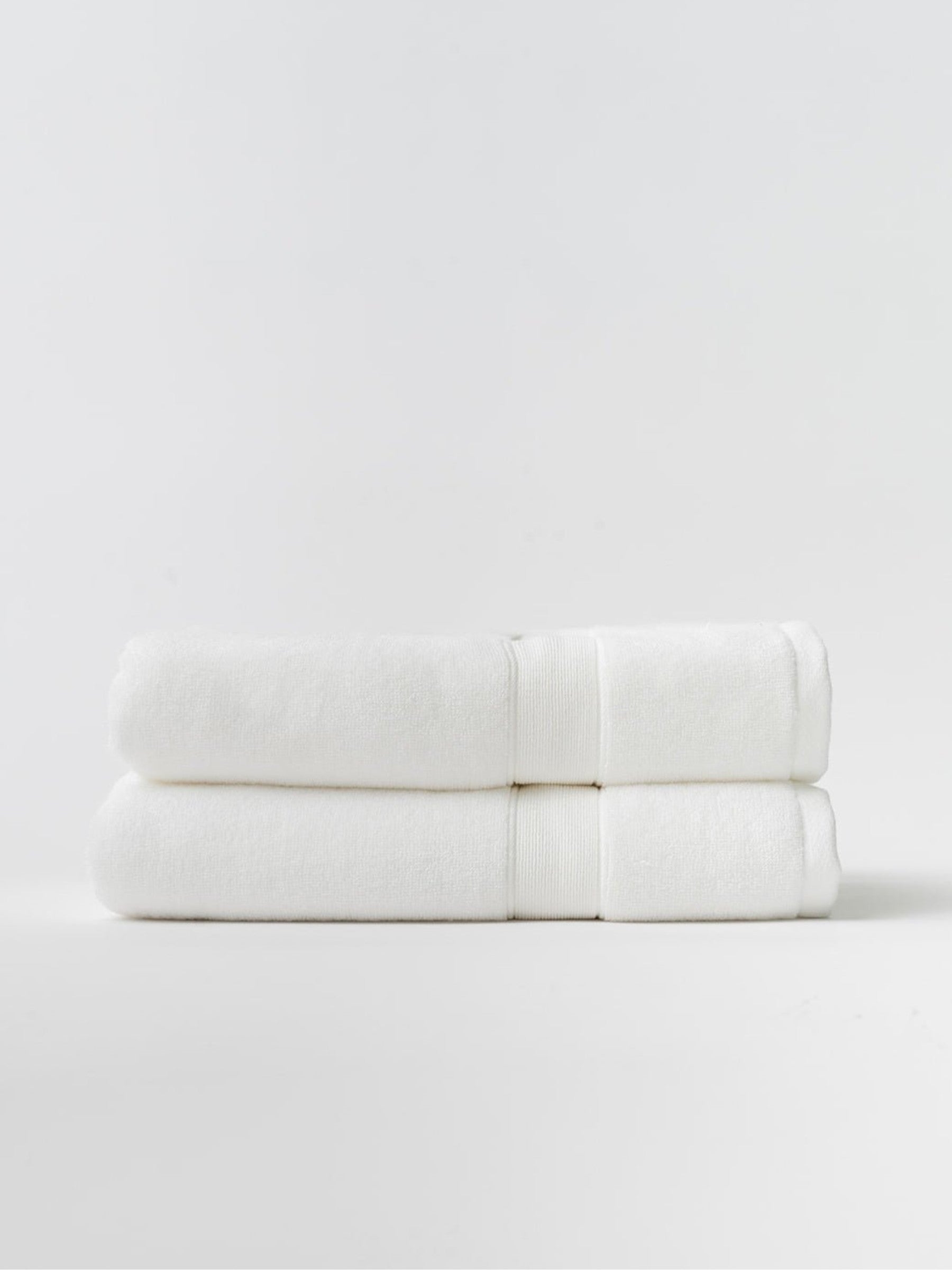 White luxe bath towels folded with white background 