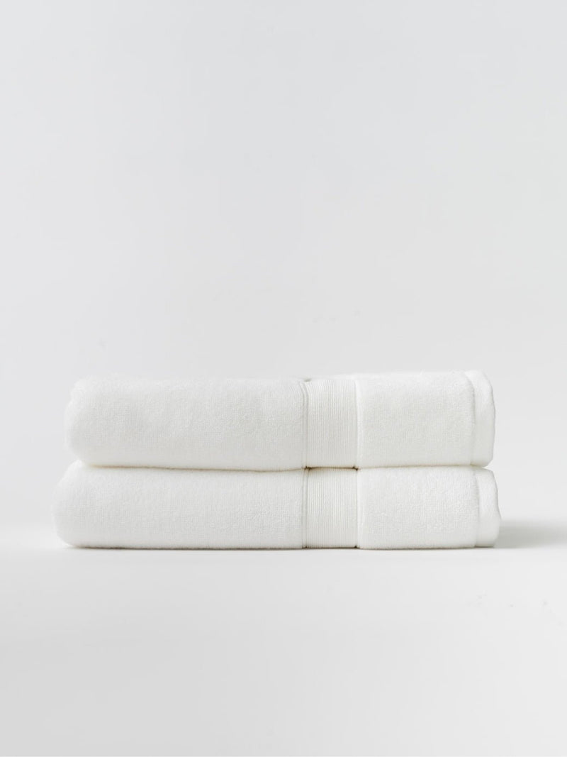White luxe bath towels folded with white background