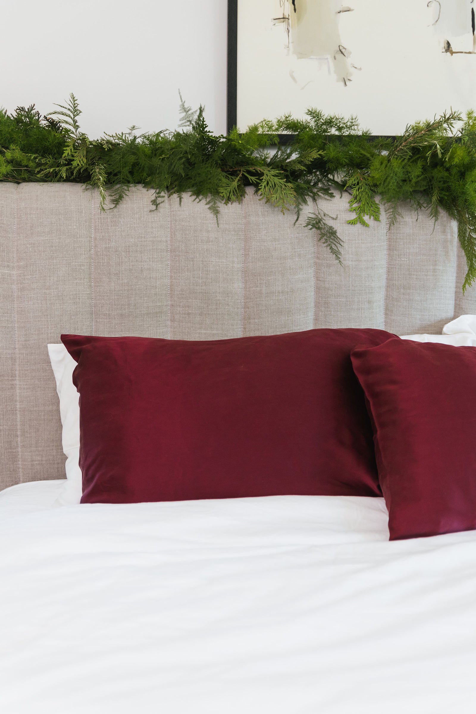 Wine silk pillowcase on bed with white bedding 