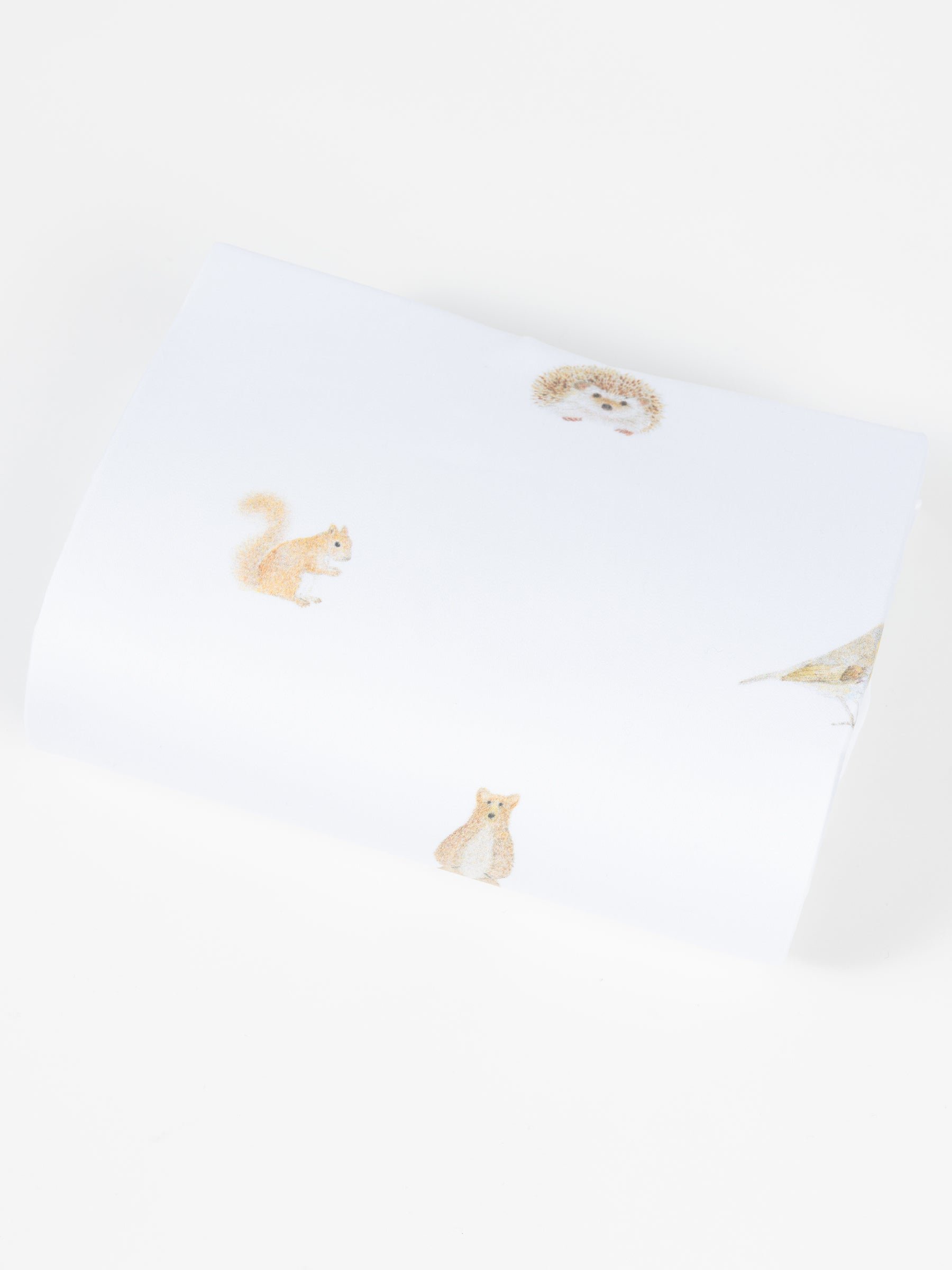 The Cozy Earth Bamboo Duvet Cover features white fabric adorned with delicate, spaced illustrations of a hedgehog, squirrel, fox, and bird against a plain background. 