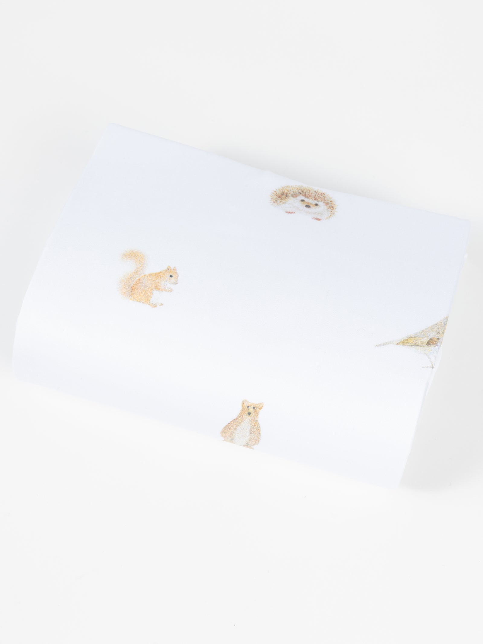 The Cozy Earth Bamboo Duvet Cover features white fabric adorned with delicate, spaced illustrations of a hedgehog, squirrel, fox, and bird against a plain background. 