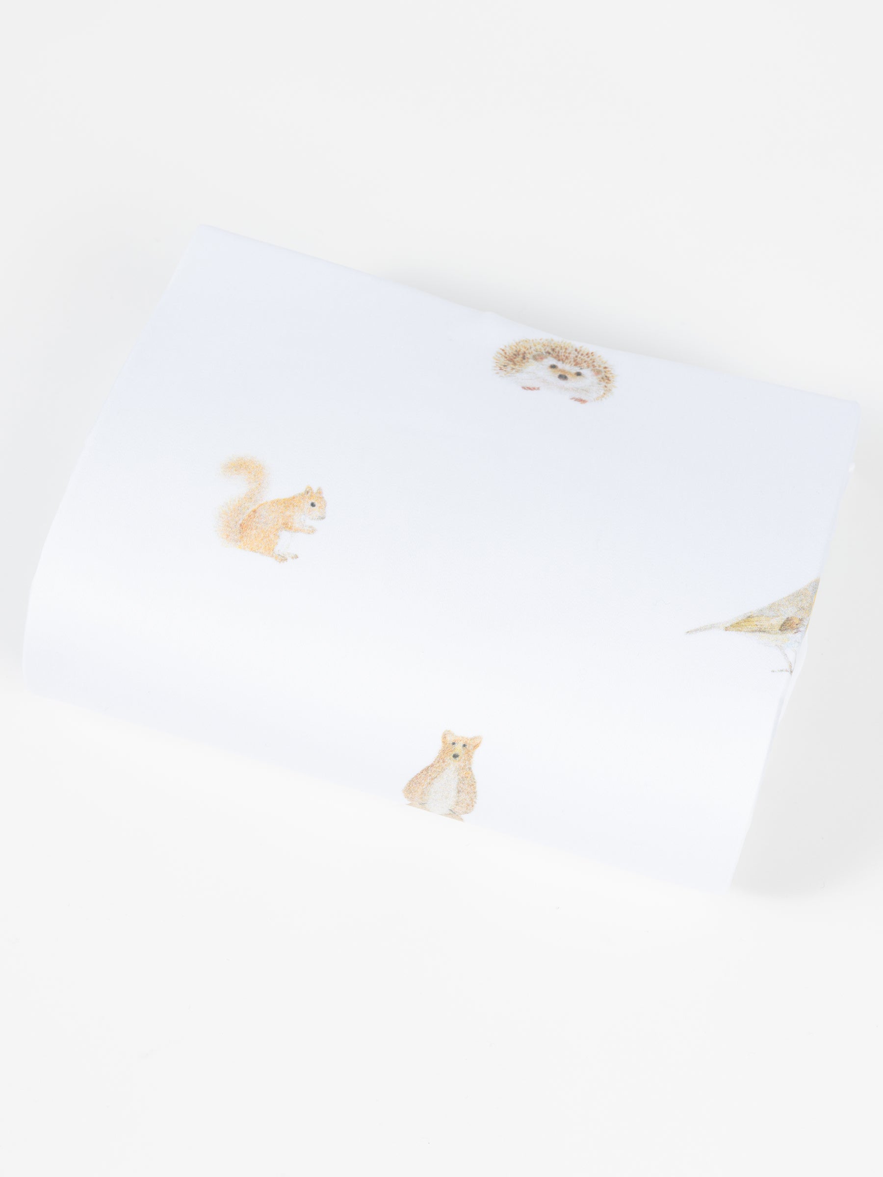 The Cozy Earth Bamboo Duvet Cover features white fabric adorned with delicate, spaced illustrations of a hedgehog, squirrel, fox, and bird against a plain background. 