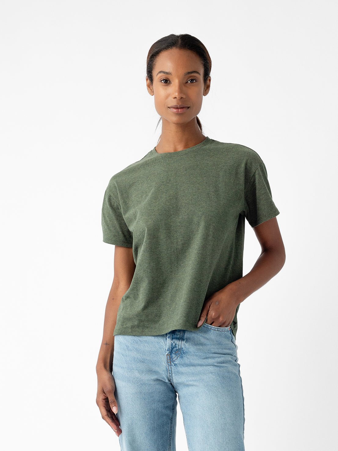 A person wearing the Cozy Earth Women's All Day Tee in green and blue jeans stands against a white background with one hand in their pocket. |Color:Olive Heather