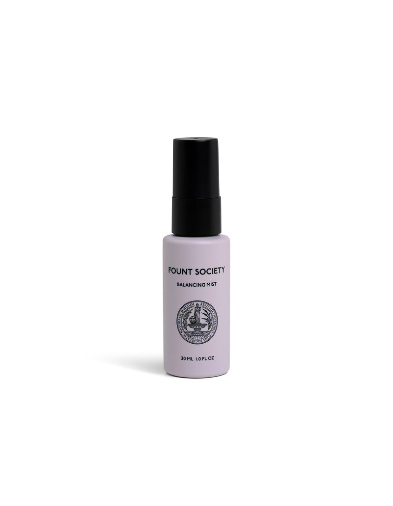 A small, white spray bottle labeled "Cozy Earth Balancing Face Mist" with a black cap and circular logo stands upright on a white background.