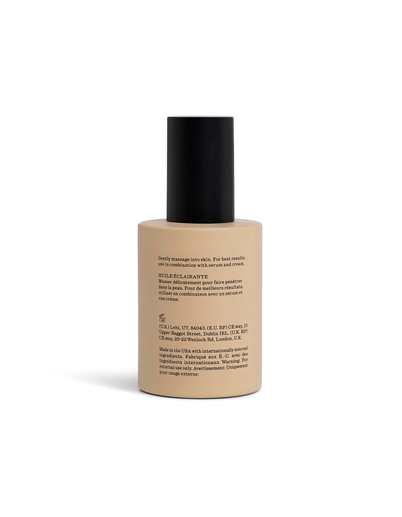 A beige bottle of Brightening Vitamin C oil turned towards the back with a black cap sits on a white background