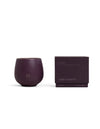 A deep purple Cozy Earth Candle EVOKE in a rounded cup with "CE" embossed on the front sits beside a matching purple box labeled "Evoke." Size: 9.2 oz (260 g).