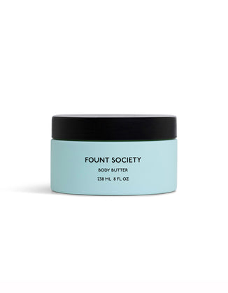A light blue jar of Cozy Earth Body Butter with a black lid, labeled 