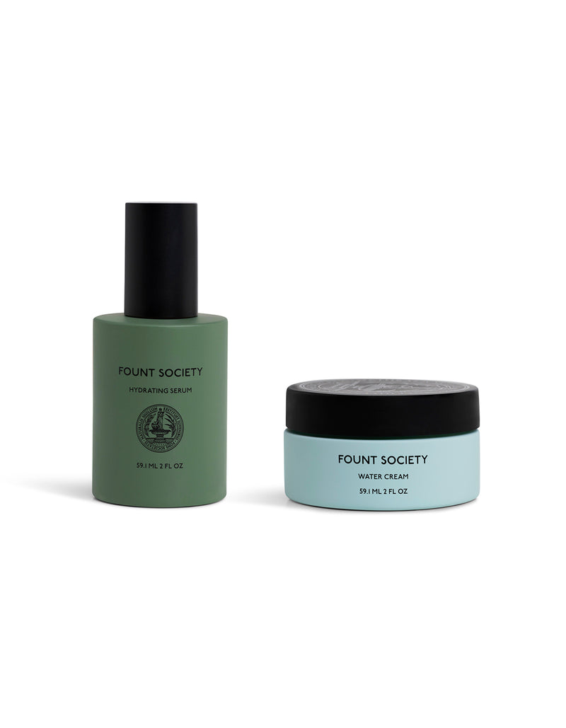 The Hydration Duo by Cozy Earth: a green-bottled hydrating serum with black pump and a light blue water cream jar with black lid, both displayed on a white background.