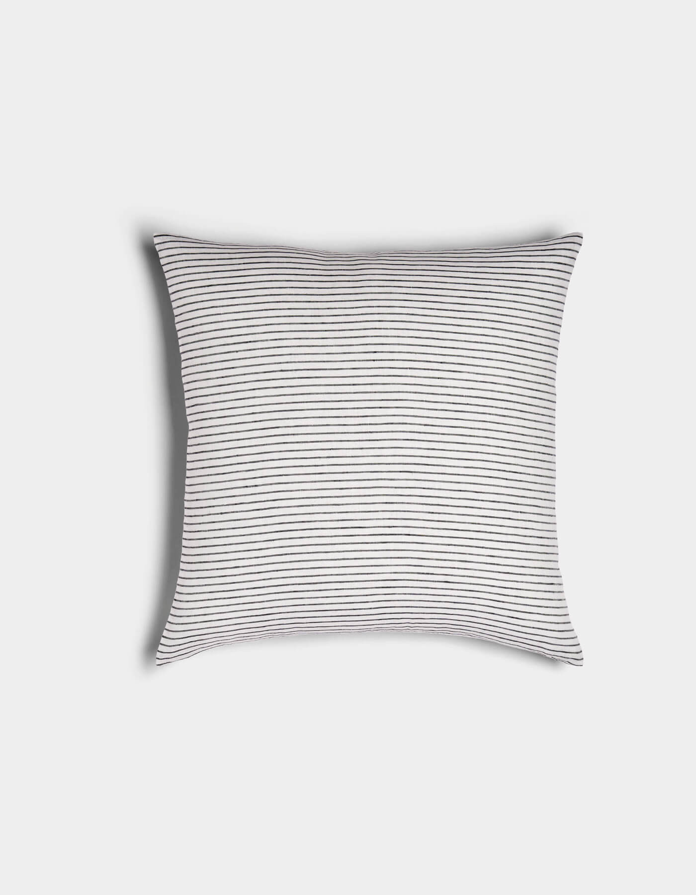 The Cozy Earth Striped Throw Pillow features a white background with thin, evenly spaced black horizontal stripes, shown against a plain white surface.