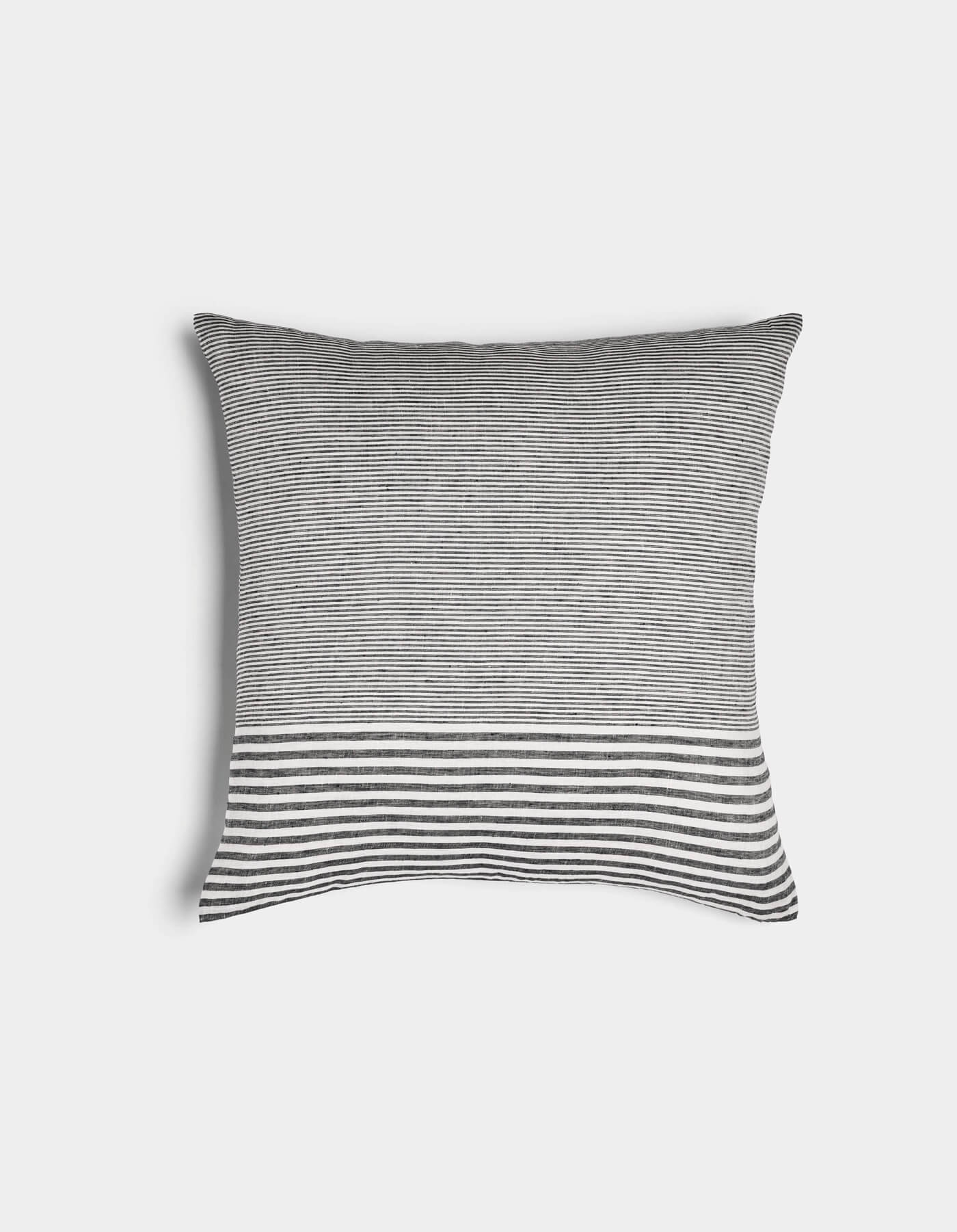The Cozy Earth Striped Throw Pillow features thin black and white horizontal stripes with a bold band of thicker stripes at the bottom, set against a plain white background.
