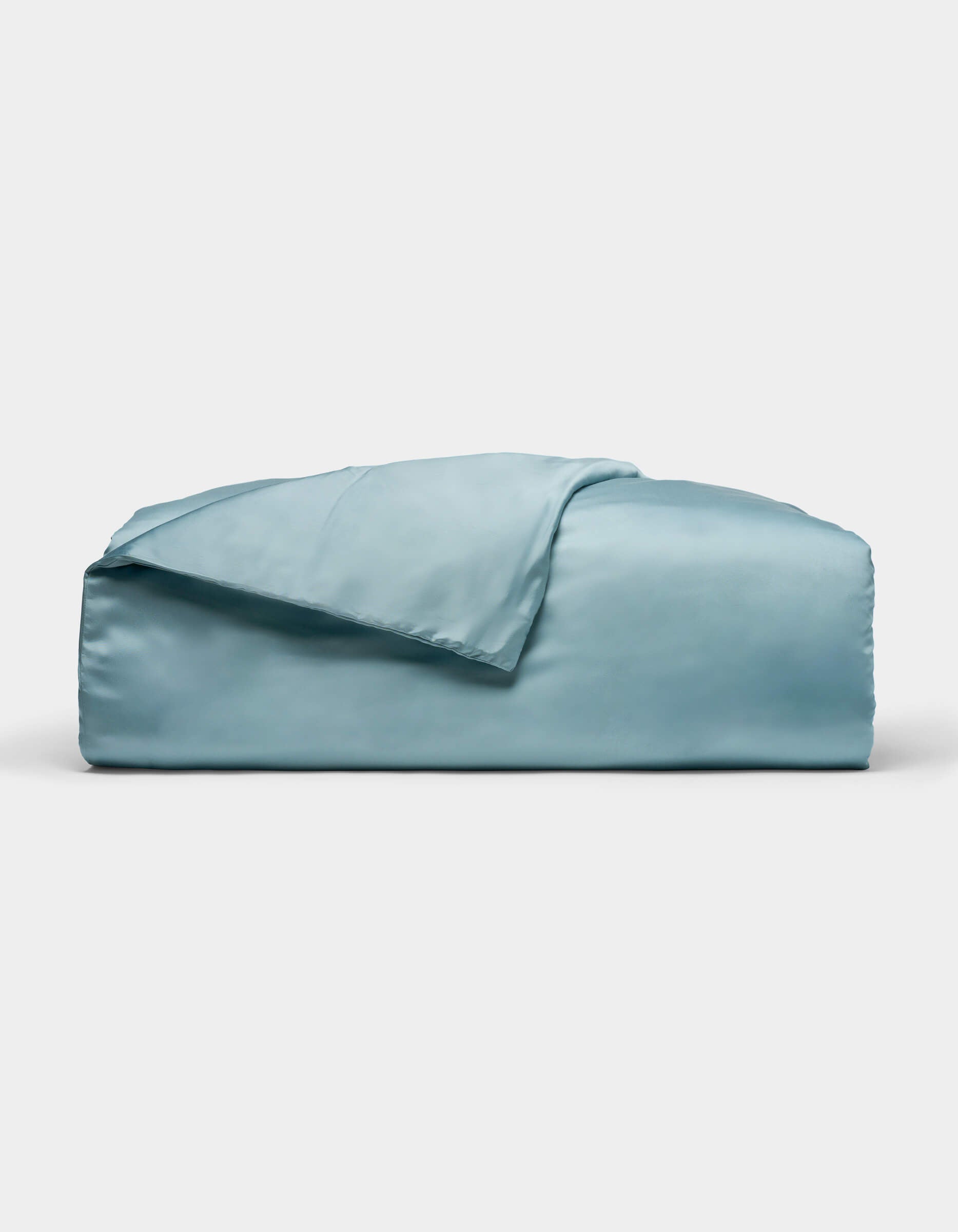 A neatly folded Cozy Earth Bamboo Duvet Cover in light blue, with one corner draped over the top, displayed against a plain white background.|Color:River