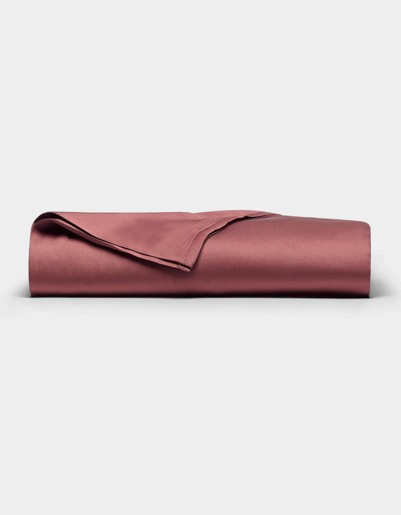 A rose-colored Bamboo Sheet Set by Cozy Earth is neatly folded and displayed against a plain white background.