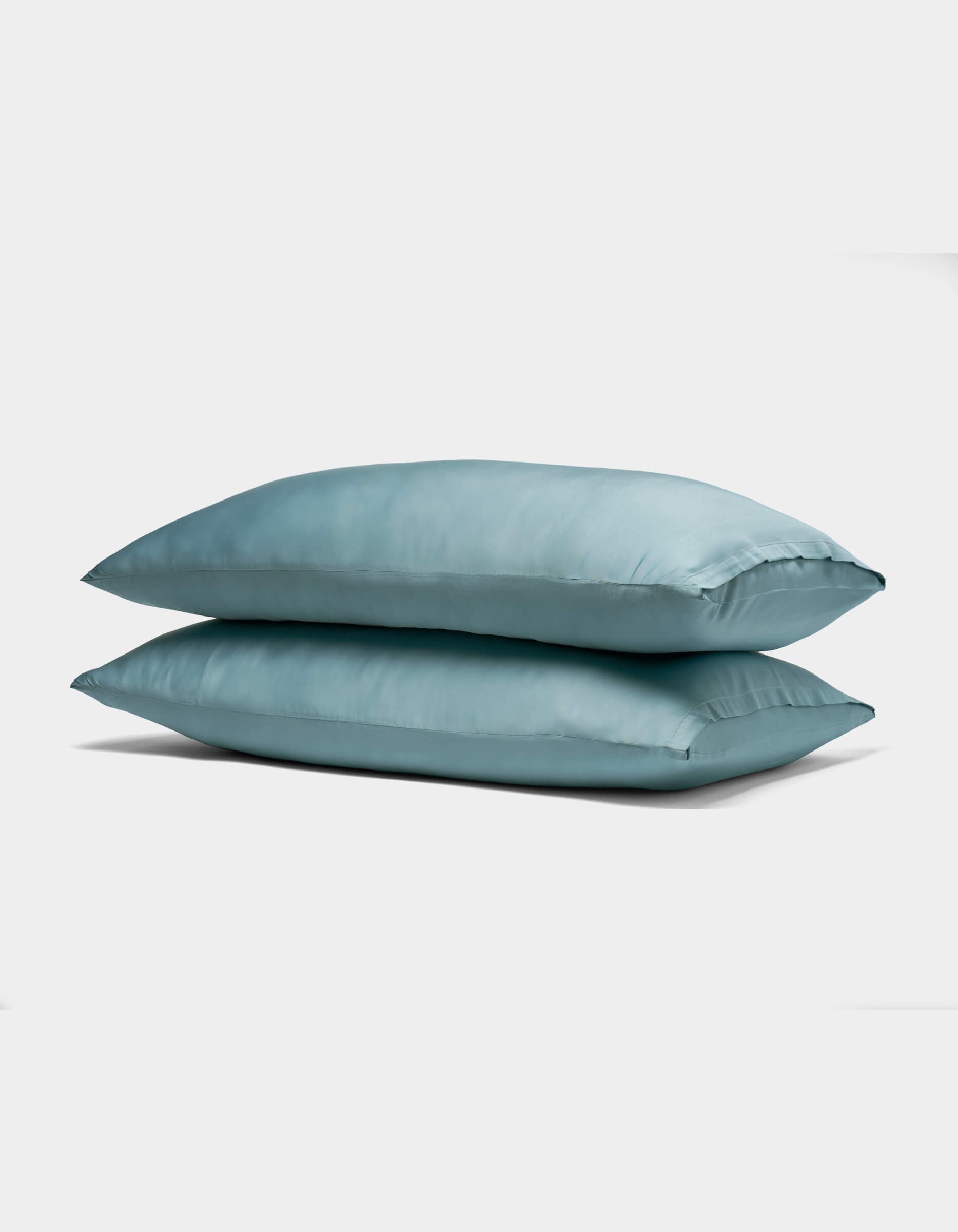 Two Cozy Earth Bamboo Pillowcases in light blue are stacked together against a plain white background.|Color:River