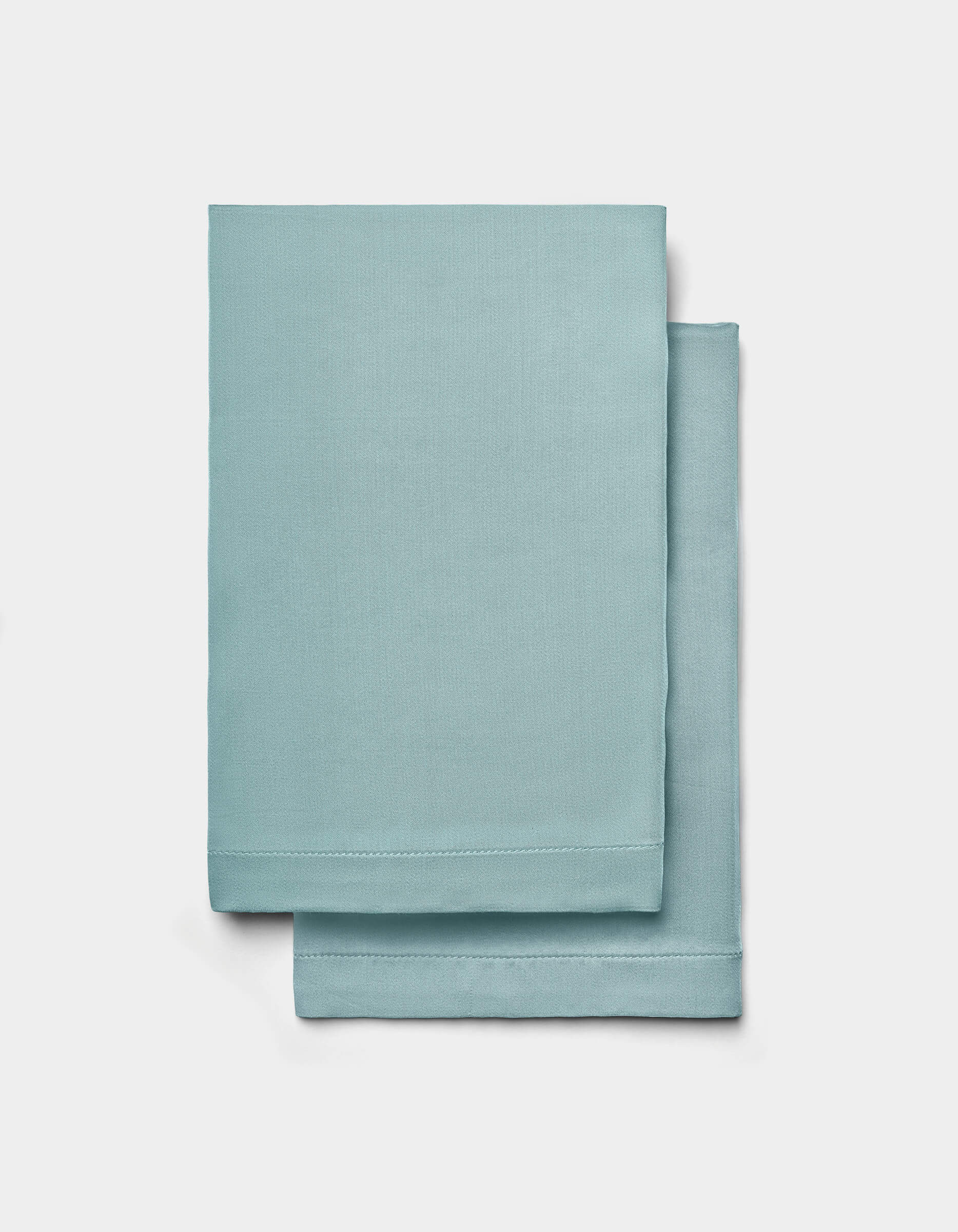 Two neatly folded Cozy Earth Bamboo Sheet Set sheets are stacked on top of each other against a plain white background.|Color:River