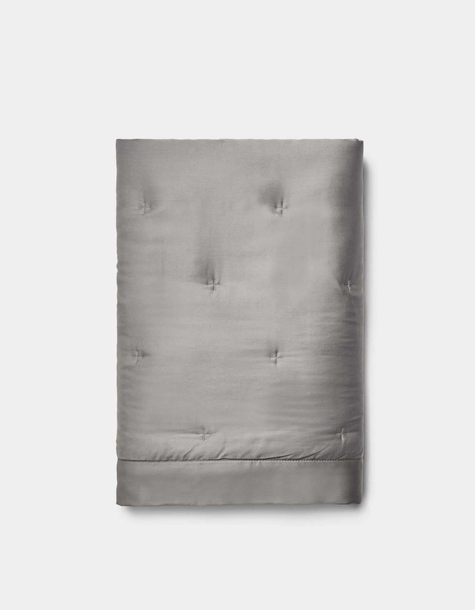 The Cozy Earth Bamboo Quilted Shams in light gray feature a smooth, slightly shiny surface with subtle tufted details, neatly folded and set against a plain white background.