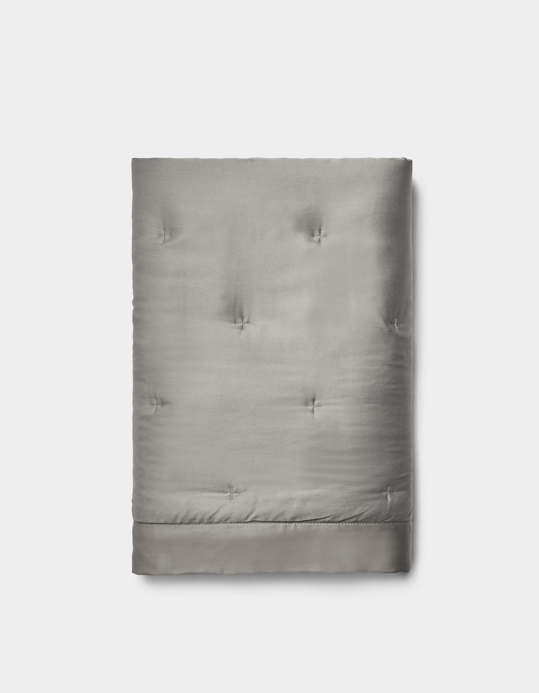The Cozy Earth Bamboo Quilted Shams in light gray feature a smooth, slightly shiny surface with subtle tufted details, neatly folded and set against a plain white background.