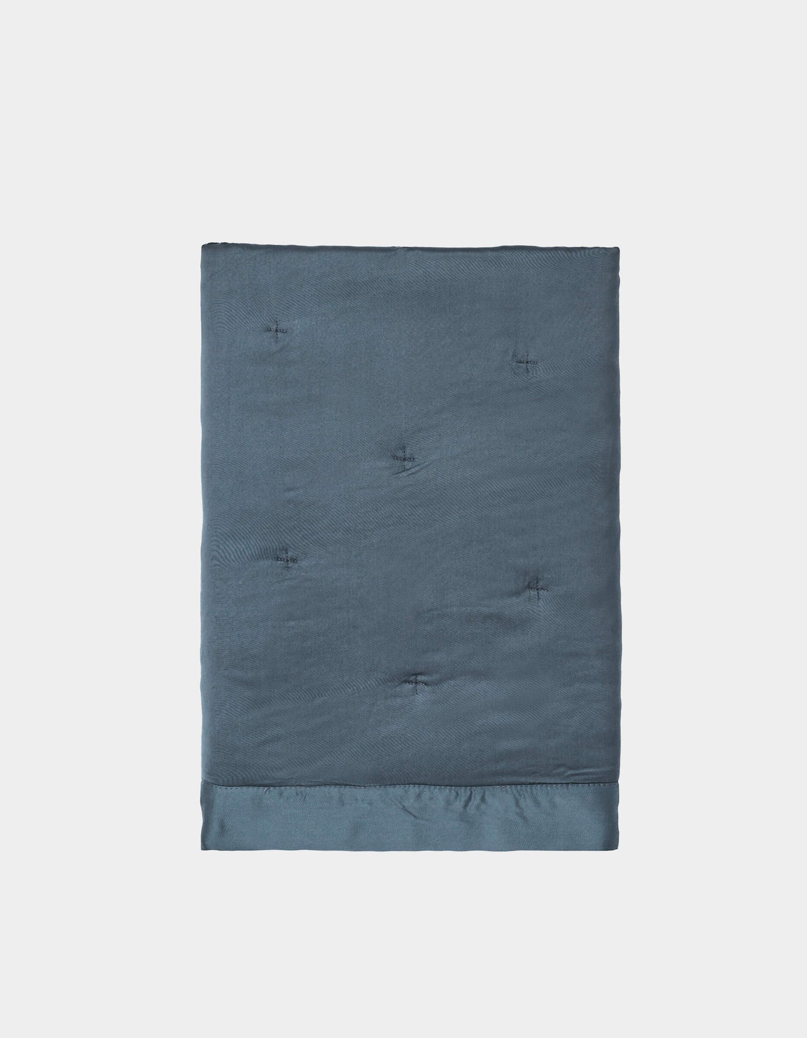A pair of neatly folded, dark blue Bamboo Quilted Shams by Cozy Earth, featuring a smooth, slightly shiny texture and subtle tufted details, displayed against a plain white background.