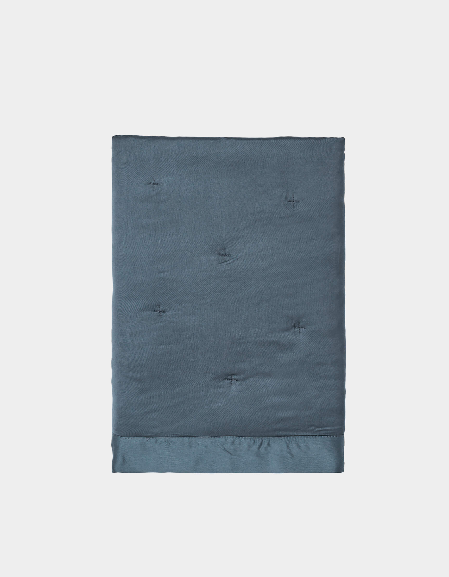 A pair of neatly folded, dark blue Bamboo Quilted Shams by Cozy Earth, featuring a smooth, slightly shiny texture and subtle tufted details, displayed against a plain white background.