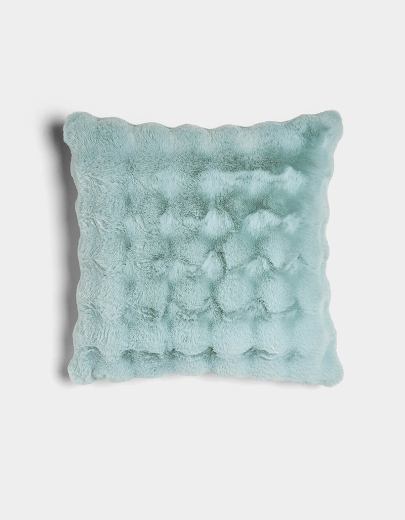 The Cozy Earth Bubble Cuddle Pillow is a square, light blue plush pillow with a soft, fuzzy texture and gently wavy edges, displayed against a plain white background.