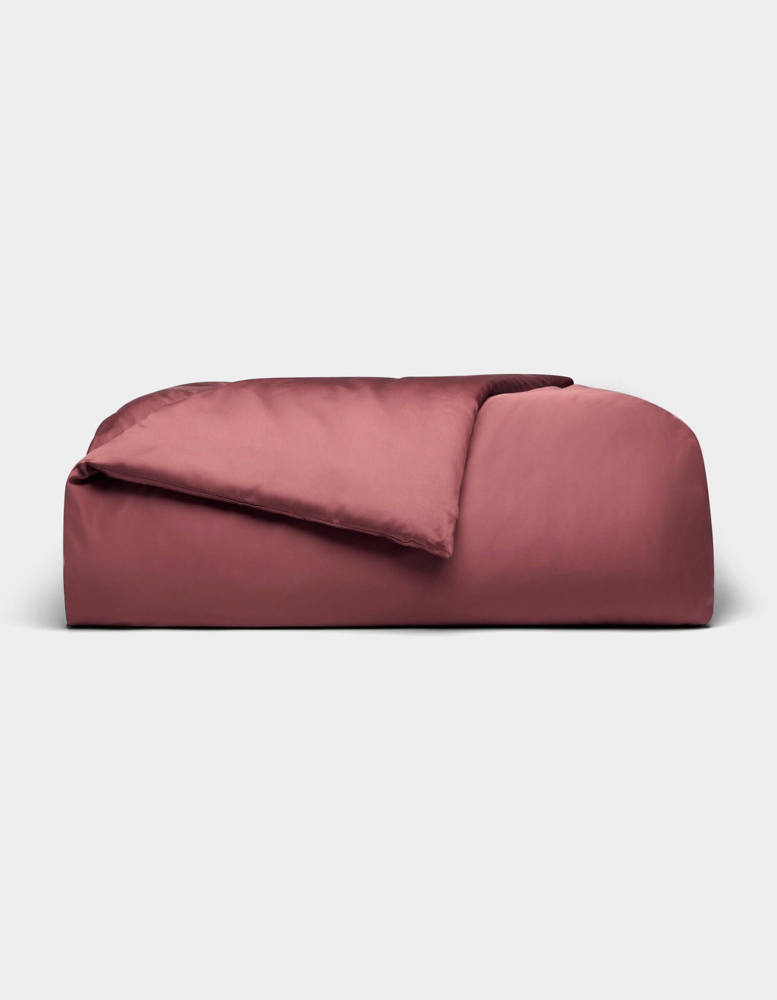 A rectangular, rose-colored Bamboo Duvet Cover from Cozy Earth with a soft, smooth texture and a gentle top fold, displayed against a plain light gray background.