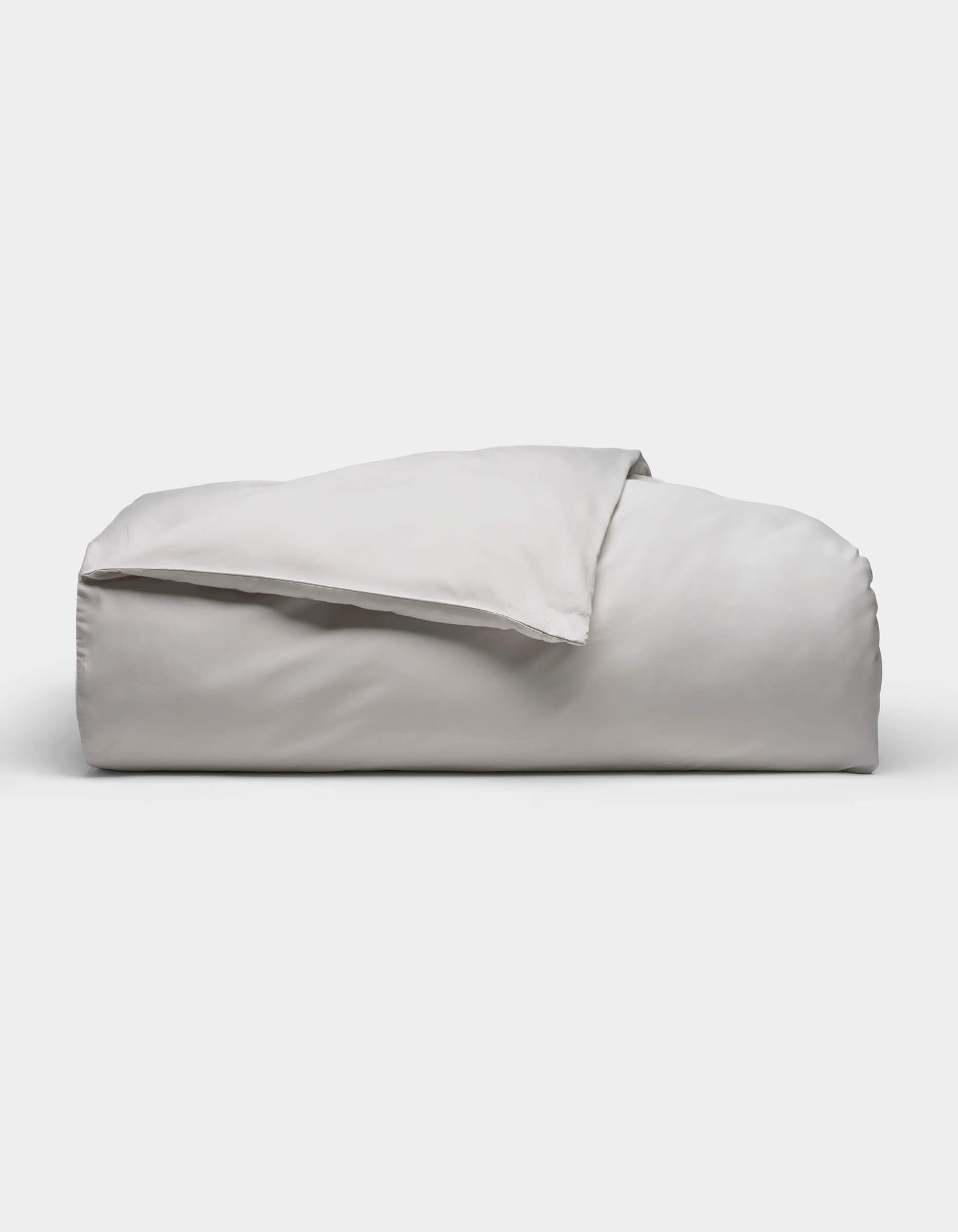 The Soft-Wash Cotton Duvet Cover by Cozy Earth, shown neatly folded in light gray with a smooth, soft texture, is displayed against a plain white background.
