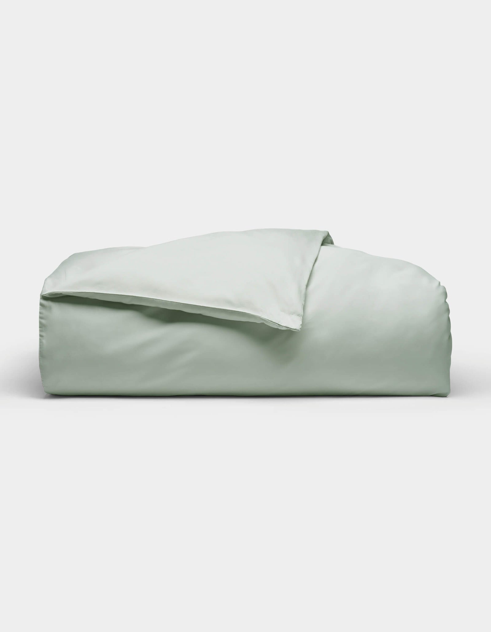 The Soft-Wash Cotton Duvet Cover by Cozy Earth, shown neatly folded in light green, is displayed against a plain white background.