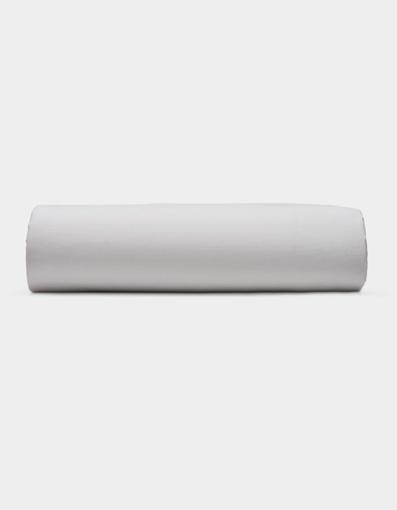 A Soft-Wash Cotton Fitted Sheet by Cozy Earth is displayed lying flat on a light surface with a neutral background.