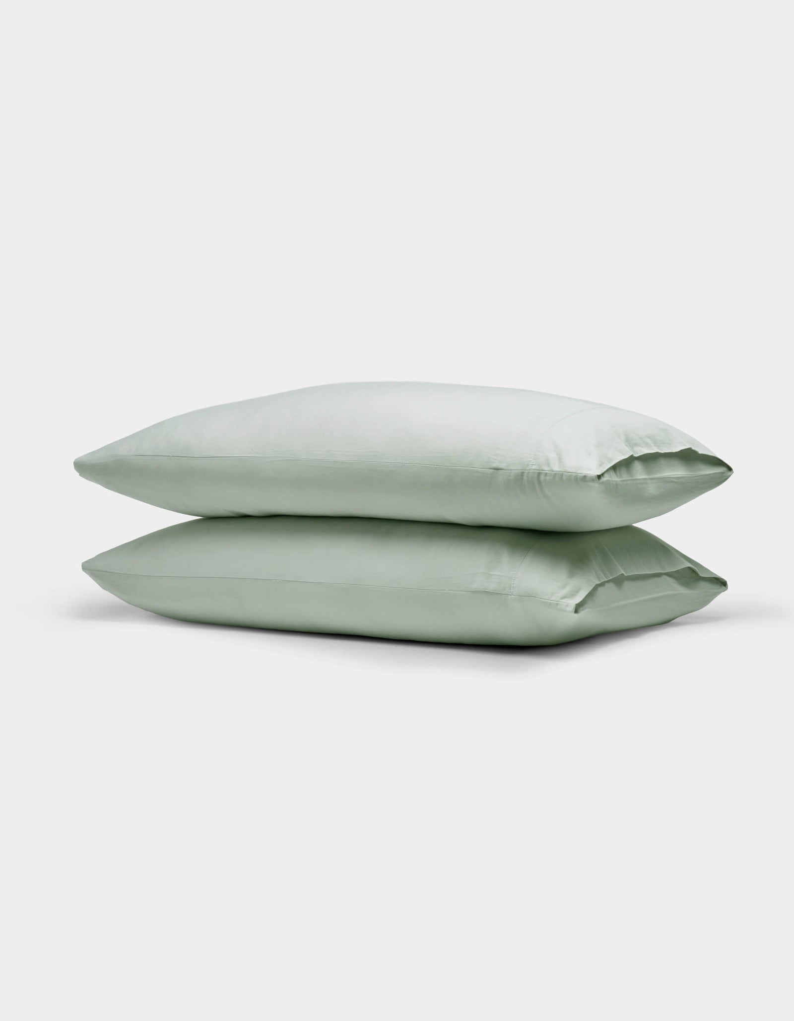 Two Cozy Earth Soft-Wash Cotton Pillowcases in light green are neatly stacked against a plain white background.