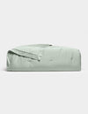The Soft-Wash Cotton Quilt by Cozy Earth, in light green with a stitched edge, is neatly folded and displayed on a plain white background.|Color:Laurel