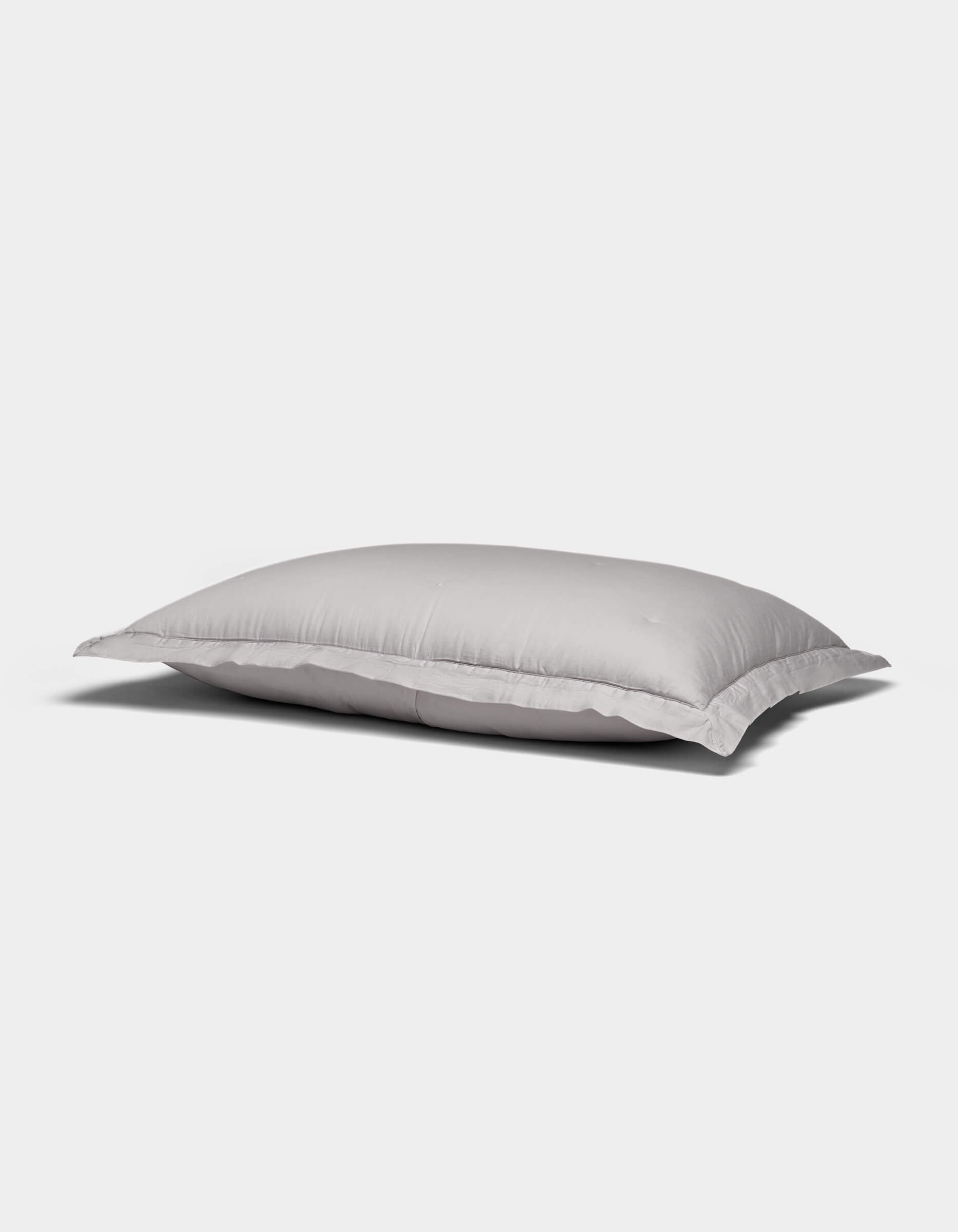 A Soft-Wash Cotton Quilted Sham by Cozy Earth, white and rectangular with a smooth surface, rests on a plain light gray background.|Color:Dew