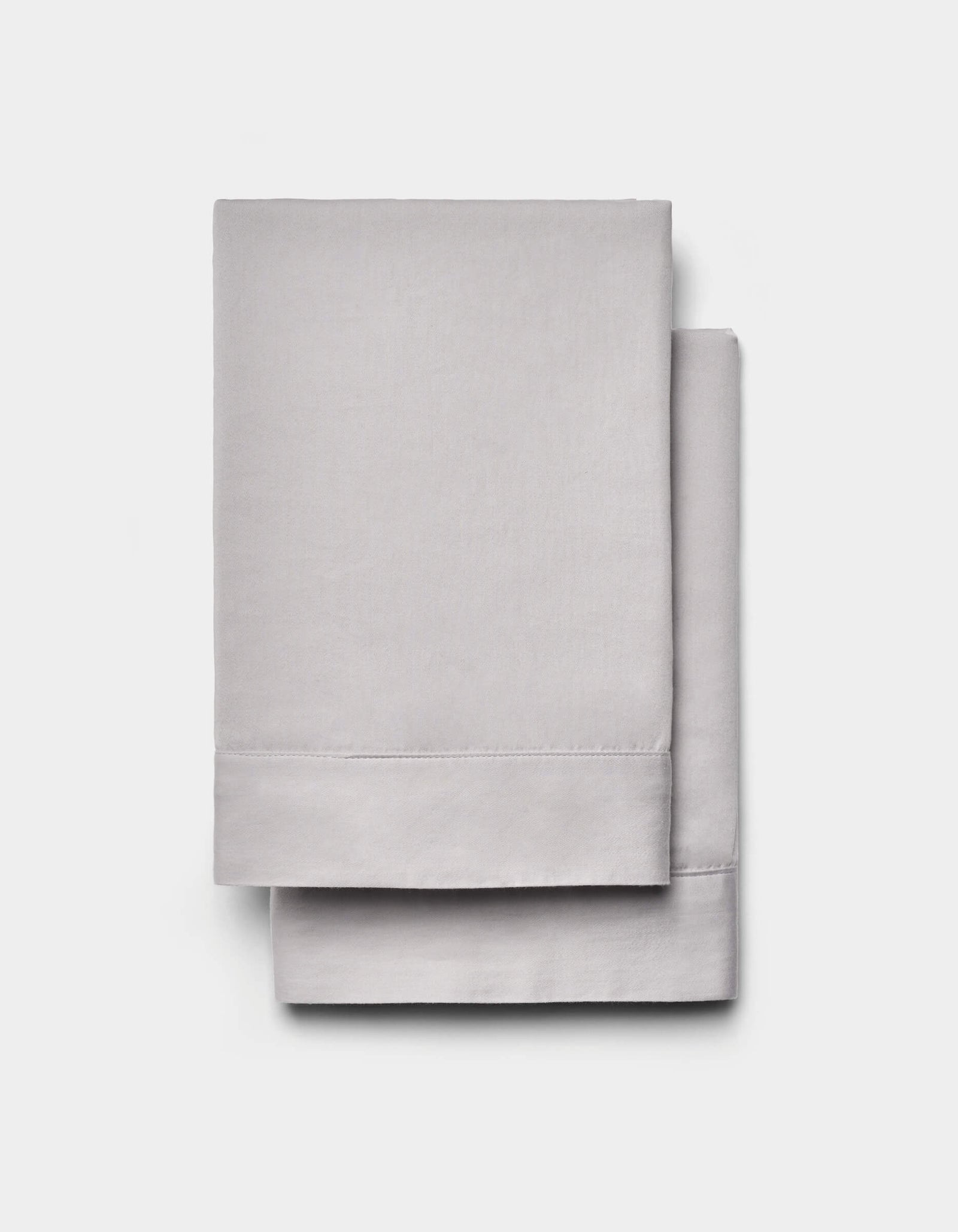 Two neatly folded Cozy Earth Soft-Wash Cotton Shams in light gray are stacked atop each other against a plain white background.