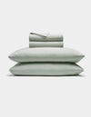 The Cozy Earth Soft-Wash Cotton Sheet Set includes a neatly folded light gray fitted and flat sheet with two stacked pillows, displayed against a plain white background.|Color:Laurel