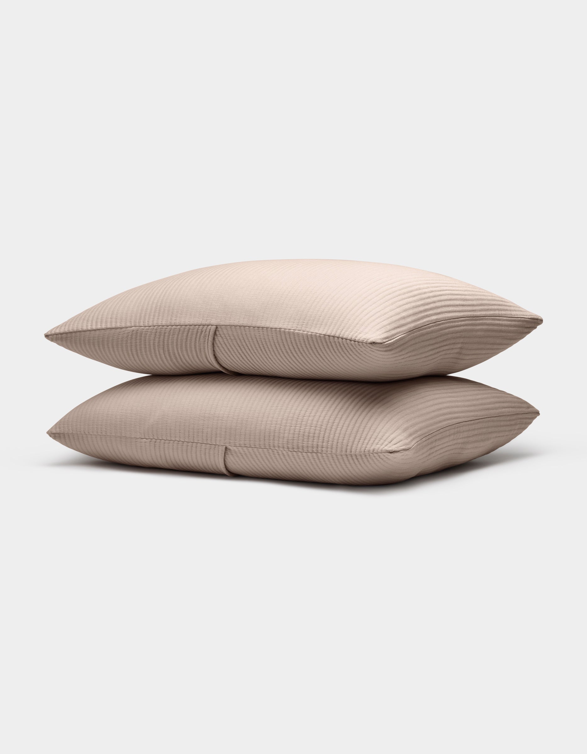 Two Bamboo Coverlet Shams by Cozy Earth, in light beige with a subtle ribbed texture, are stacked neatly against a plain white background.