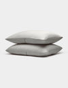 Two neatly stacked Bamboo Coverlet Shams by Cozy Earth, light gray with a subtle striped pattern, are displayed on a plain white background.|Color:Light Grey