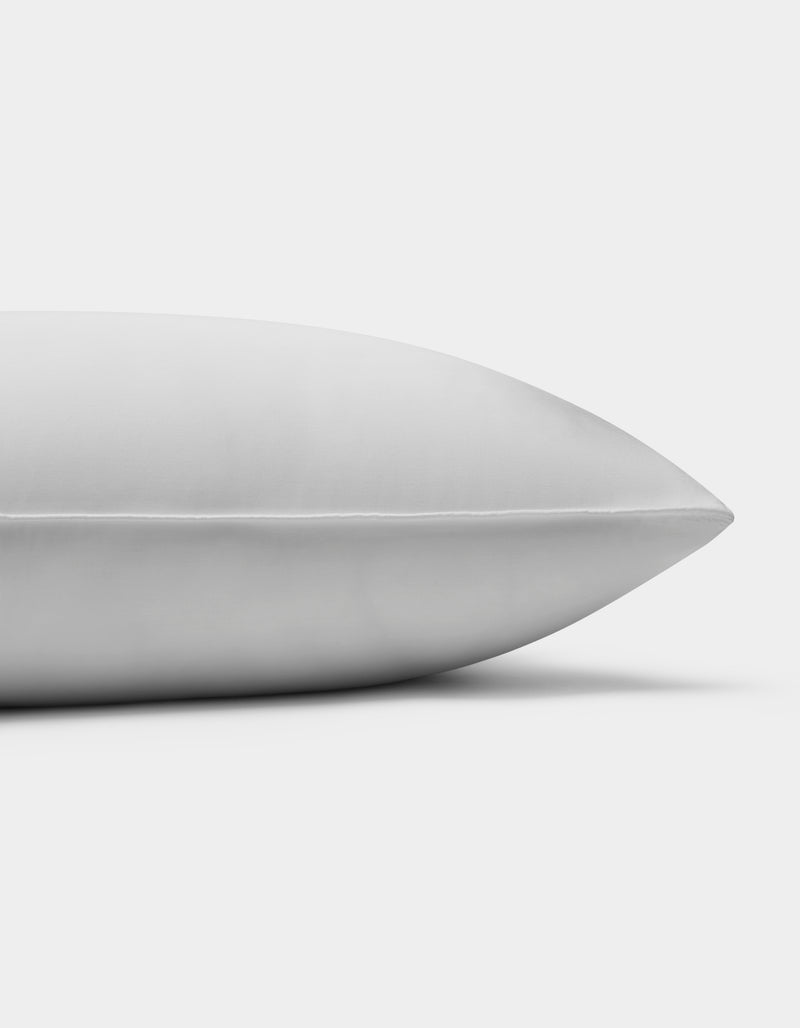 A close-up side view of the Cozy Earth Bamboo Down Alternative Pillow, featuring a smooth white surface, resting on a plain white background.Standard King