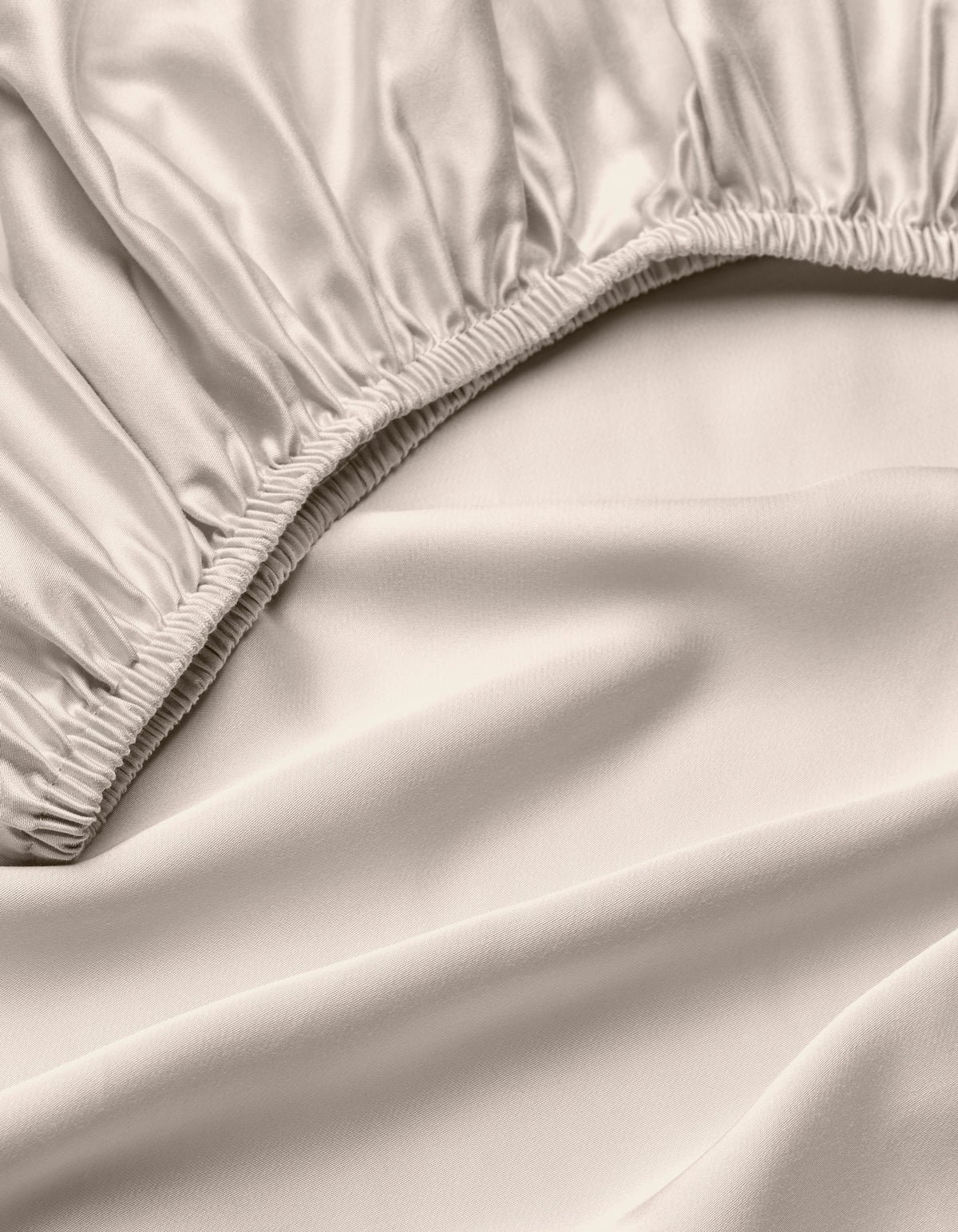 A close-up of the Cozy Earth Bamboo Fitted Sheet in light beige, highlighting its silky, smooth fabric, gathered elastic edges, and soft folds.|Color:Driftwood