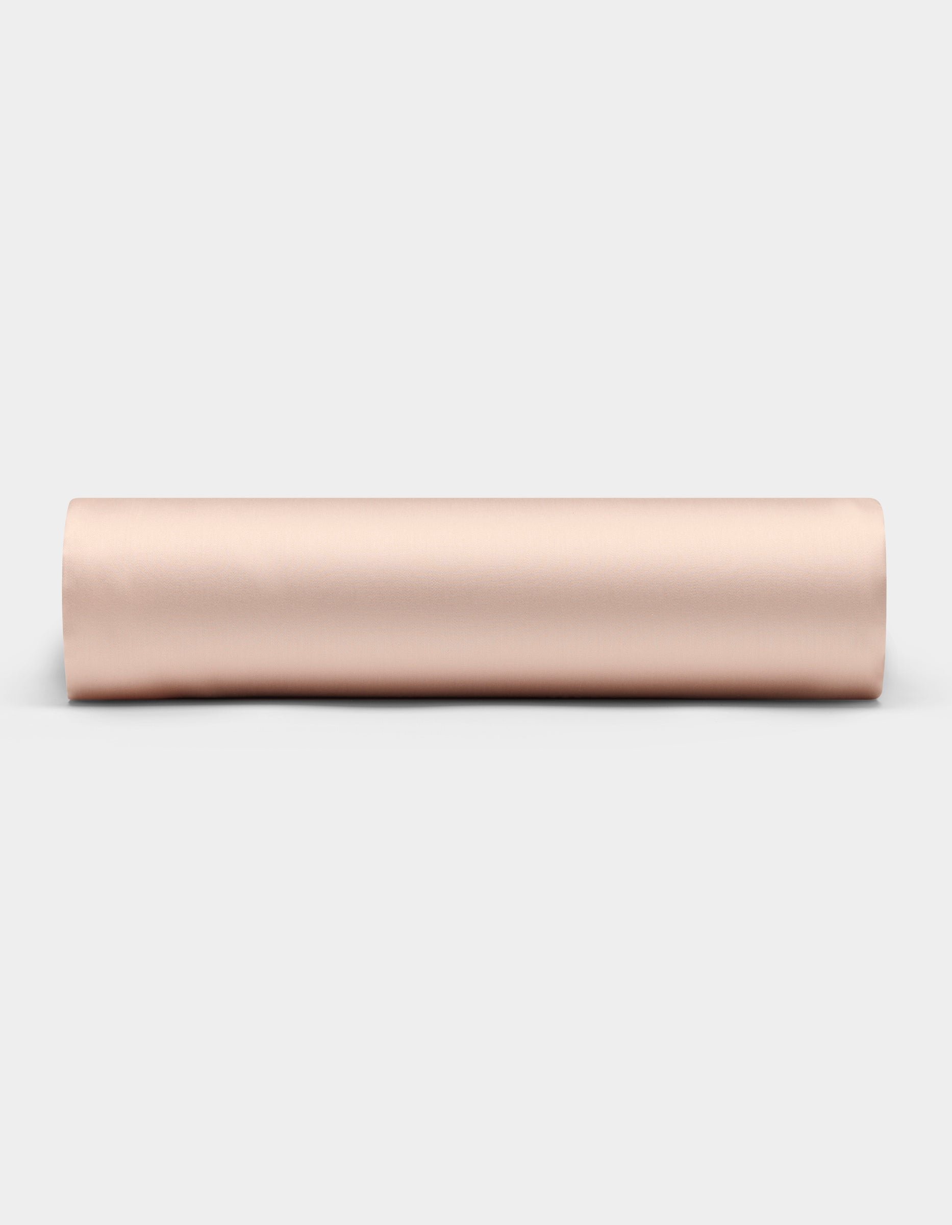 A Cozy Earth Bamboo Fitted Sheet in a light beige shade is shown rolled up on a plain white background, viewed from the side.