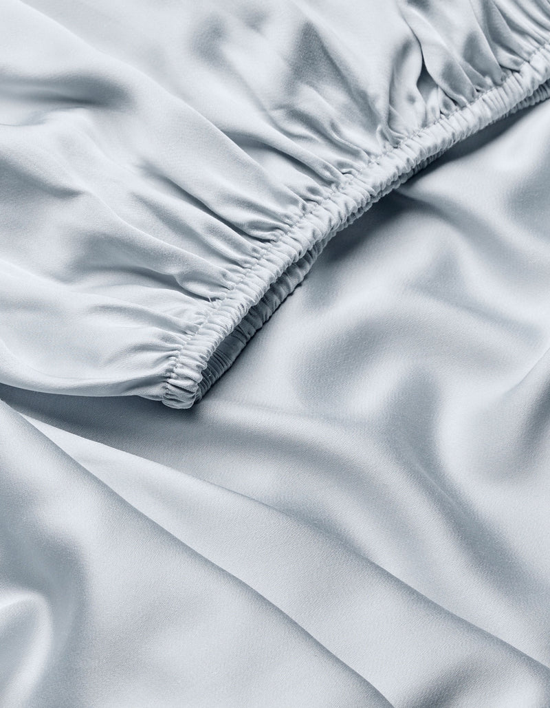 Close-up of Cozy Earth Bamboo Fitted Sheet in light blue, featuring gathered, ruched stitching on one edge for soft folds and a smooth, silky sheen.