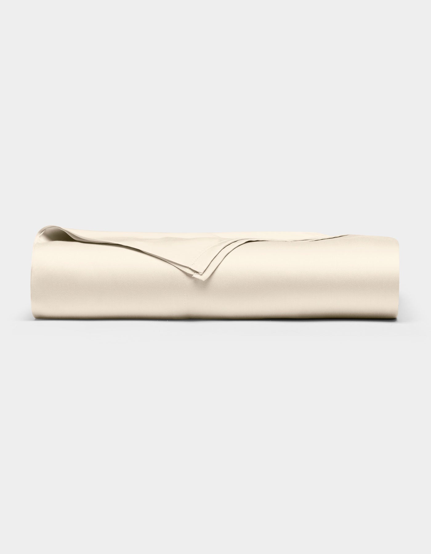 The Cozy Earth Bamboo Flat Sheet, in a light beige color, is neatly folded and displayed against a plain, light gray background.