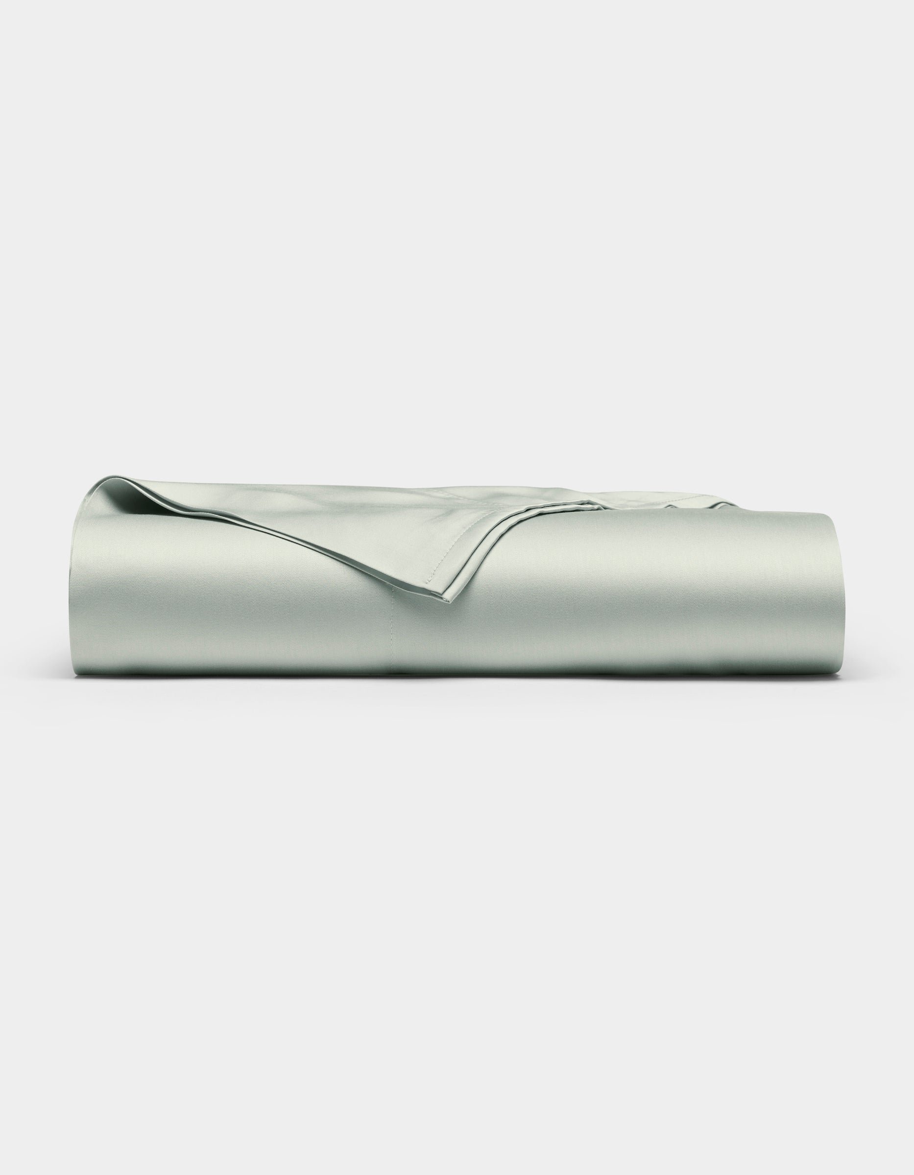 A neatly folded Bamboo Flat Sheet by Cozy Earth in light gray is displayed against a plain white background.