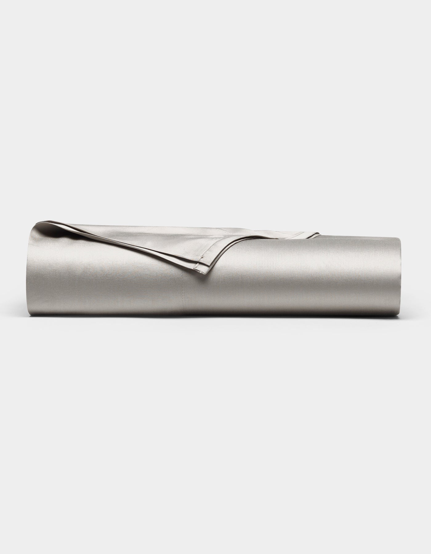 The Cozy Earth Bamboo Flat Sheet, shown in light gray with one corner folded over, is neatly rolled up and displayed against a plain white background.
