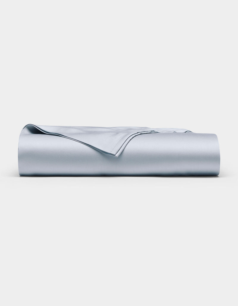 The Cozy Earth Bamboo Flat Sheet in light blue is neatly folded and displayed against a plain white background.